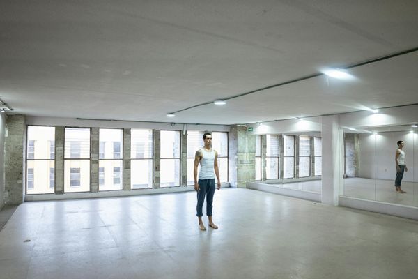 Person practicing yoga in a bright minimalistic studio space